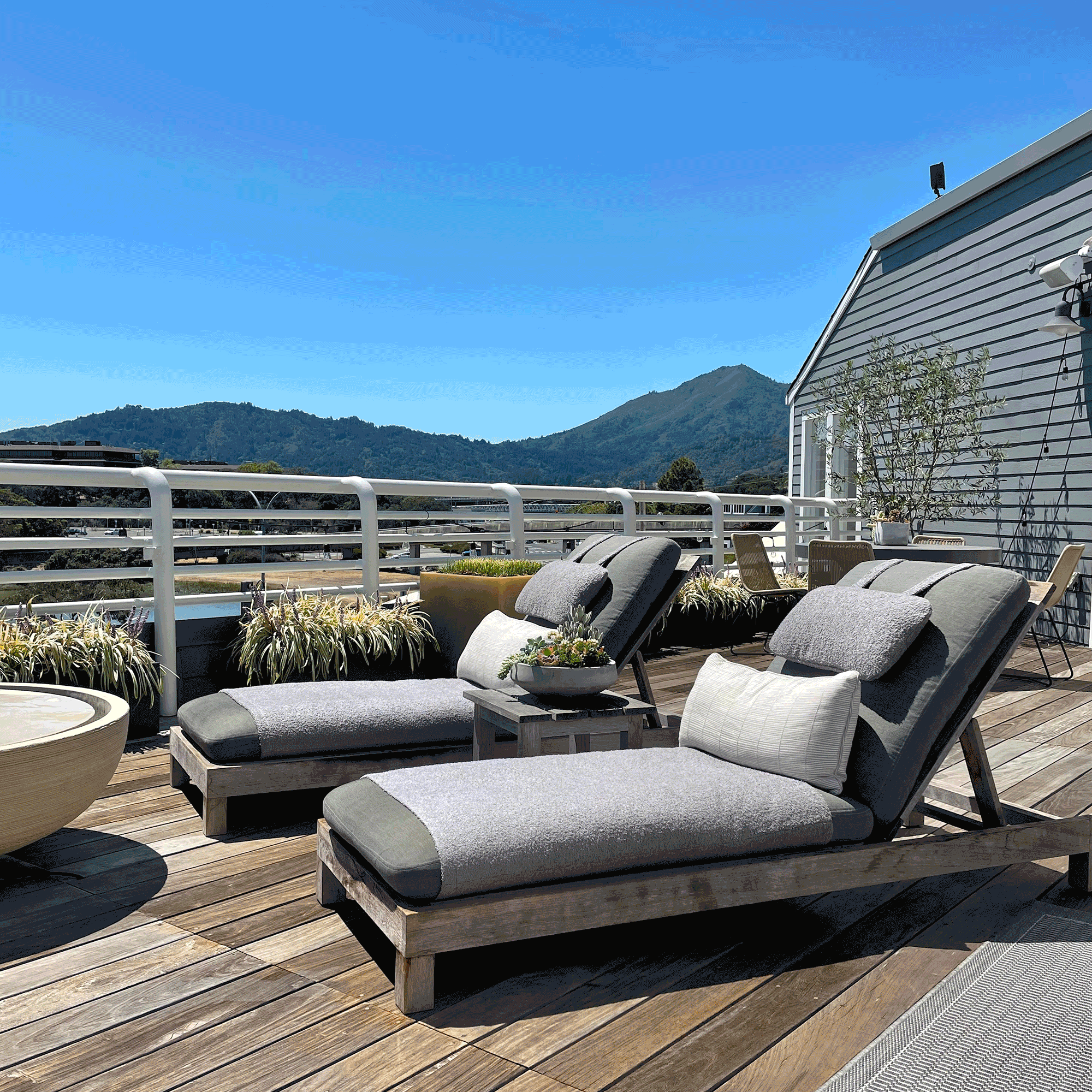 A rotating series of tranquil spa scenes from International Orange, including sunlit lounge chairs on a rooftop deck, neatly displayed skincare products, and calming interior moments designed to evoke relaxation and wellness.
